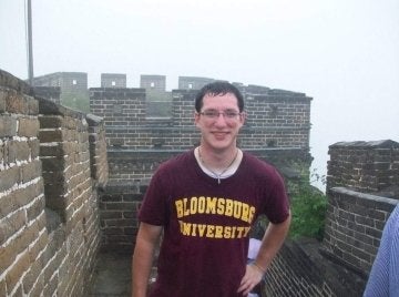 A man standing at the Great Wall of China. 