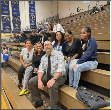 Group of people sitting on bleachers.