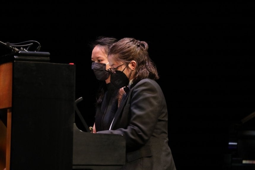 Two people playing piano. 