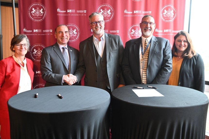 A group standing behind tables. 