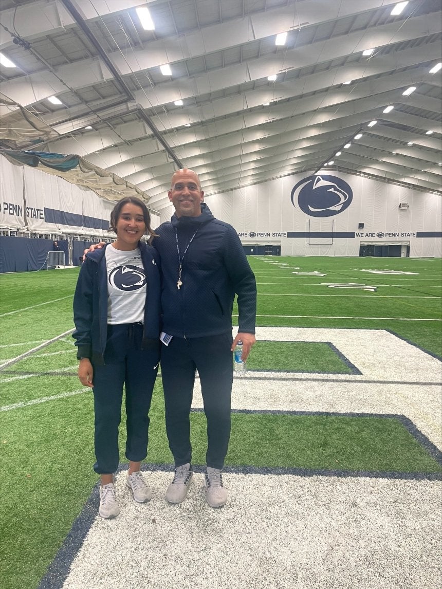 Two people standing together on a field. 