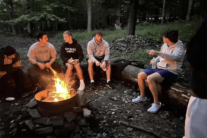 Quest students around a bonfire