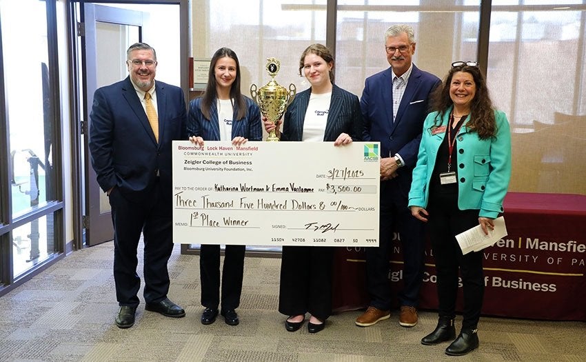 2025 Husky Dog Pound winners Katharina Wortmann & Emma Vantomme pose for photos with giant check.